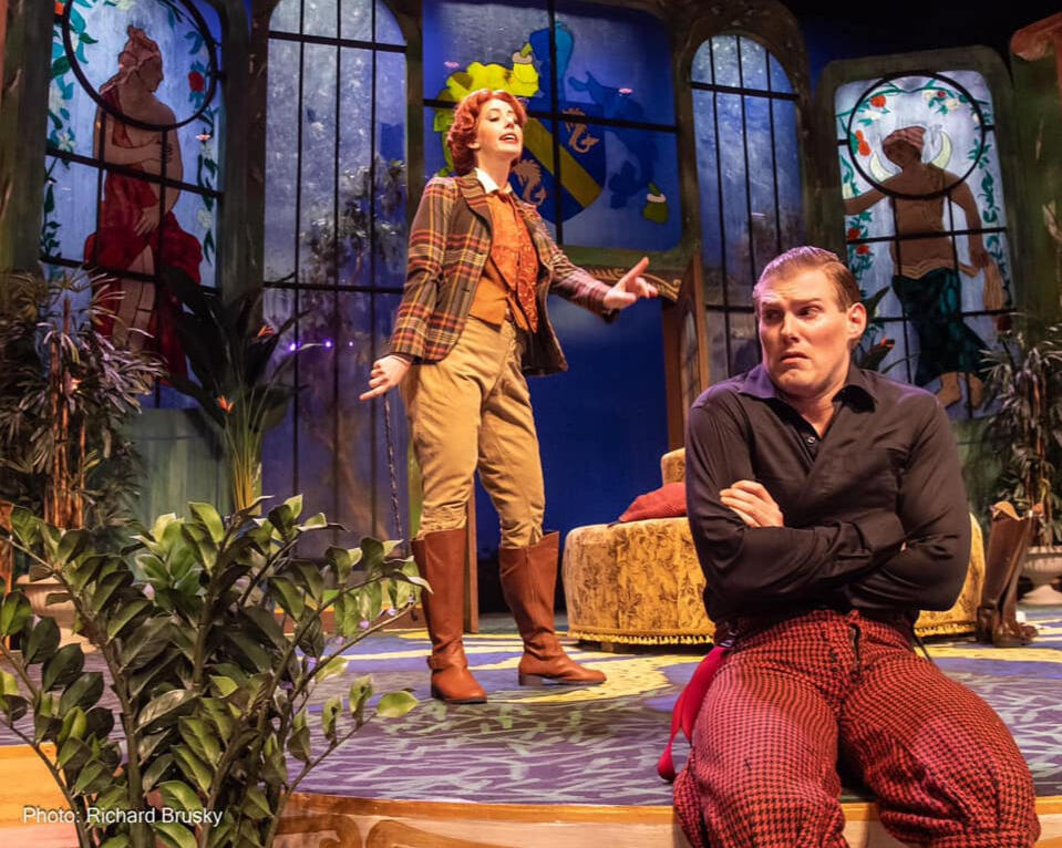 Ring Round the Moon by Christopher Fry (2021) A women lecturing a man who sitting on the edge of the stage.